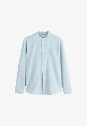 Gaiši zils, garām piedurknēm krekls ar lentes apkakli, priekšā pogas aizdare un krūšu kabata. Izgatavots no teksturēta, elpojoša auduma.