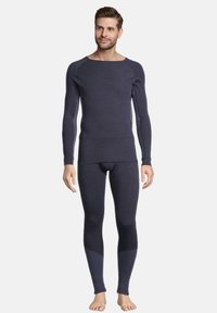 Dunkelgraues, langärmeliges Thermoshirt und enganliegende Hose. Glatte Textur, Rundhalsausschnitt und kontrastierende Einsätze an den Beinen. Leichtes Material.