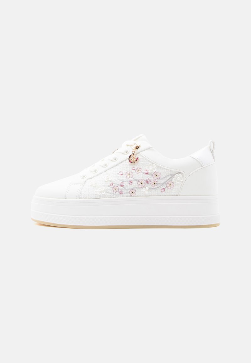 Zapatillas de plataforma blancas con parte superior texturizada, bordado floral en rosa y un charm dorado en los cordones. Suela de goma lisa.