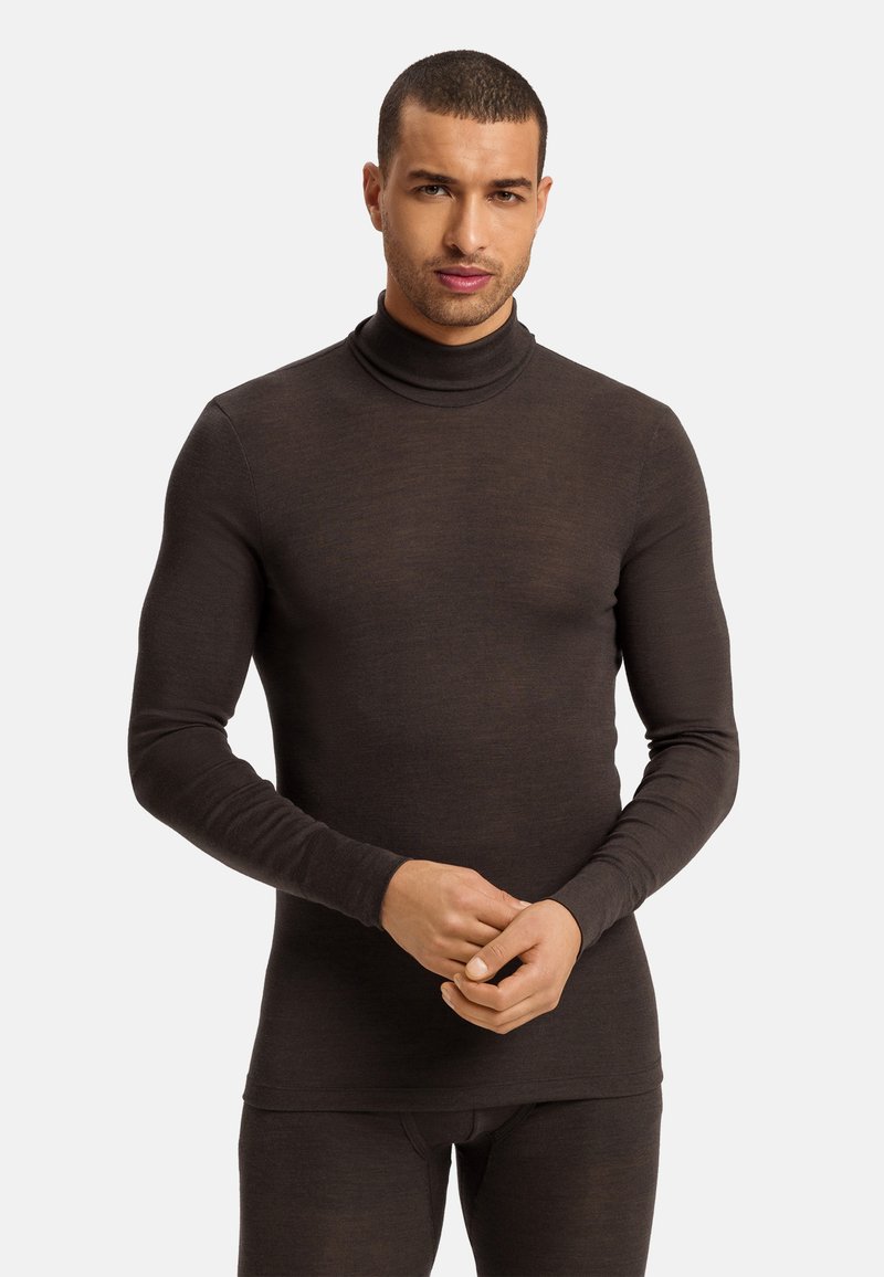 Brązowy sweter z długim rękawem, wykonany z delikatnej tkaniny, o dopasowanym kroju, z wysokim kołnierzem i bezszwowym wykończeniem mankietów, w komplecie z dopasowanymi spodniami.