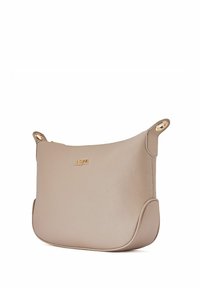 Beżowa skórzana torba na ramię o gładkiej fakturze, zakrzywionym kształcie, złotych detalach i wytłoczonym logo na przodzie. Zamek błyskawiczny.