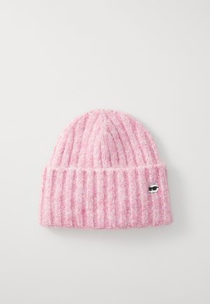 Roze gebreide beanie met een geribbelde textuur. Heeft een kleine katgrafiekspeld aan de voorkant, gemaakt van een zachte, pluizige stof.