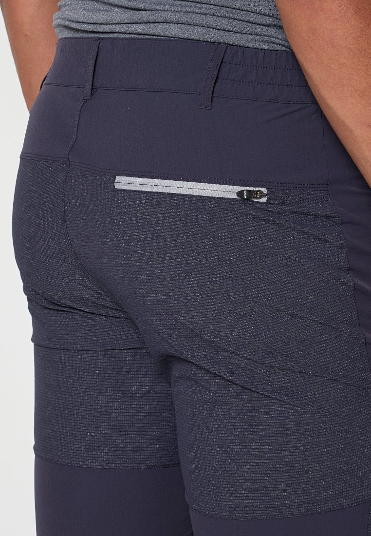 Pantalones deportivos de color navy con tejido texturizado, que cuentan con un bolsillo trasero con cremallera segura y una cinturilla plana para mayor comodidad.