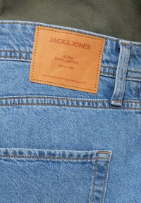 Φωτεινά γαλάζια τζιν από denim με καφέ δερμάτινη ετικέτα που αναγράφει «Jack & Jones Jeans Intelligence» και λεπτομέρειες ραφής.