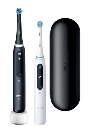 Zwei elektrische Zahnbürsten, eine schwarze auf einer Ladestation und eine weiße, neben einem schwarzen Reiseetui, alle Oral-B iO Modelle.