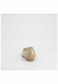Ballerine beige in pelle con punta rotonda, dettagli cuciti e un piccolo fiocco decorativo davanti. Finitura opaca e liscia.