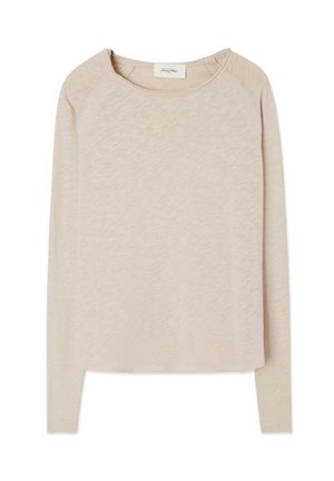 Beige long-sleeve top with a soft, textured fabric. Features a round neckline and raglan sleeves. Curved hem with a relaxed fit.