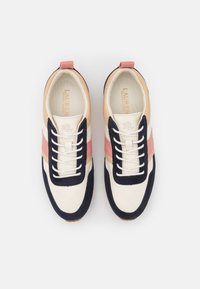 Låga sneakers med en överdel i krämfärgad läder, navymocka accentuerande detaljer, rosa och beige ränder samt vita snören på en texturerad brun sula.