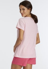 Striped pink t-shirt made of cotton, featuring short sleeves and a round neck, paired with solid pink shorts. Simple and relaxed fit.