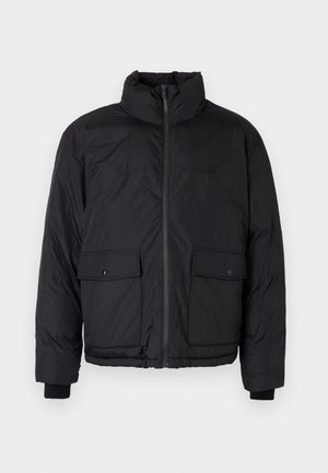 Must musta jakk, millel on seisva kaelusega, ees lukk ja kaks esimist taskut klappidega. Omab tekstuuri ja elastseid mansette.