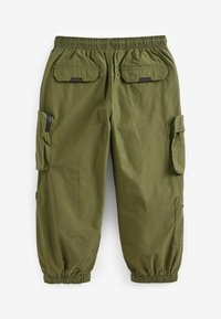Olivenfarvede cargo bukser med elastisk talje, flere lommer, herunder to klaplommer, og elastiske manchetter ved anklerne.