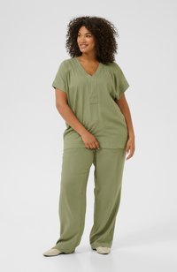 Olive green two-piece outfit featuring a loose V-neck top and wide-leg pants, made of soft fabric with a smooth texture and relaxed fit.