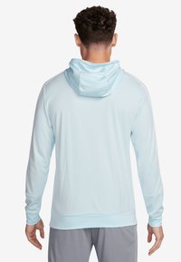 Lichtblauwe hoodie met een gladde textuur, lange mouwen en een ronde onderzoom. Bevat een eenvoudig ontwerp zonder zichtbare logo's.
