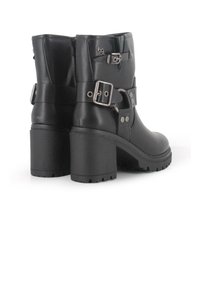 Botas de ante negra hasta el tobillo con un tacón grueso, que presentan hebillas laterales, acentos de remaches y suelas texturizadas para un mejor agarre.