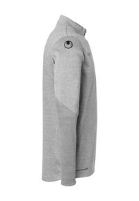 Grijze lange mouw shirt met een kraag, voorzien van een textuurdetail op de schouder en een logo op de bovenarm. Gemaakt van zachte, ademende stof.