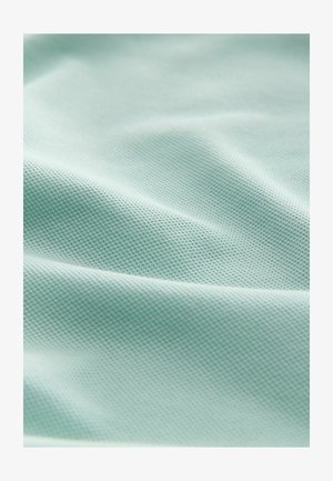 Textured light mint-green fabric with a smooth surface, featuring a fine pattern. The material appears flexible and drapes softly.