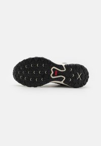 Black rubber outsole with deep treads and an off-white midsole. Features a red "NIKE" logo and textured patterns for grip.