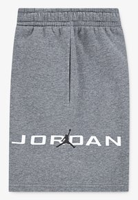 Šedé bavlnené šortky s elastickým pásom, s čiernym logom Jumpman a nápisom "JORDAN" v bielom písmene na leme.