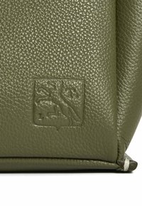 Borsa in pelle verde oliva con superficie texturizzata, caratterizzata da un logo a rilievo di un leone all'interno di uno scudo nella parte inferiore.