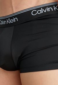 Zwarte katoenen boxershorts met een aansluitend ontwerp, voorzien van een wit Calvin Klein-logo op de tailleband en een gladde textuur.