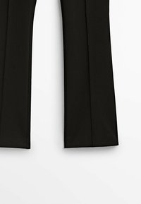 Pantalon noir à jambes droites, fabriqué en tissu lisse. Il présente une coupe nette sans ornements ni motifs visibles.