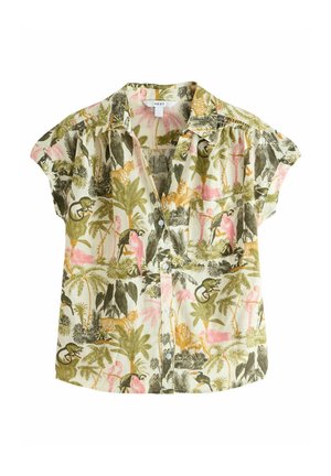 Koszula z krótkim rękawem na guziki z tropikalnym nadrukiem dżungli, przedstawiająca różowe papugi, tygrysy i zielone palmy, noszona z białymi spodniami.