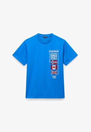 Jasnoniebieska bawełniana koszulka z okrągłym dekoltem, z białym tekstem, flagami i logo nadrukowanymi na przodzie w układzie pionowym.