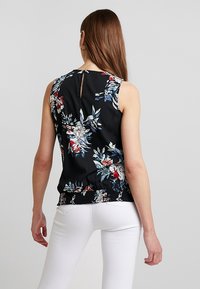 Black floral sleeveless top featuring a floral pattern in red and blue, gathered waist, and a small back keyhole opening.