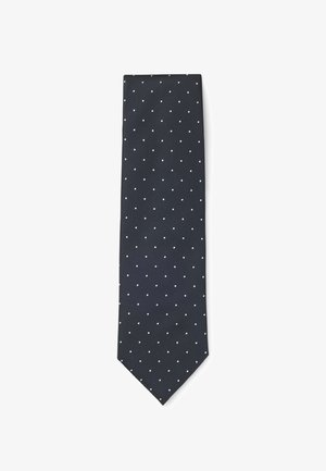 Cravatta blu navy con motivo a pois bianchi, realizzata in tessuto strutturato, presenta una punta appuntita e un design classico adatto a occasioni formali.