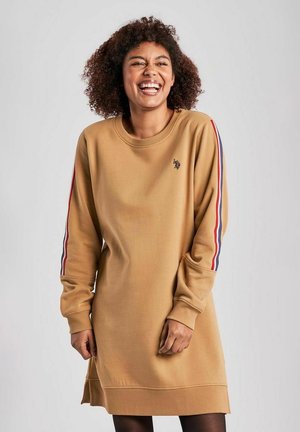 Långärmad klänning i senapsgul sweatshirtmaterial med ribbade ärmslut, prydd med röda, blå och vita sidostripes samt en liten logotyp på bröstet.
