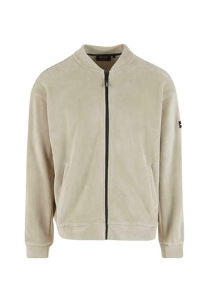 Jasnobežna bomber jakna iz mehkega flisa, z sprednjim zipom, stranskimi žepe in rebrastimi manšetami. Minimalističen design z črnimi akcenti.