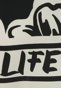 Zwart-witte stof met gedurfde, abstracte vormen en tekst die "LIFE" zegt. Zachte textuur en contrasterende kleuren versterken de visuele impact.