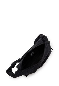 Sac en tissu noir avec fermeture éclair, présentant une surface texturée et une sangle unique d'un côté. À l'intérieur, il est doublé de noir.