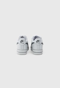 Nike Air sneakers gaišs pelēks ādas ar melniem akcentiem. Iespējas: noapaļots purngals, plakans zolīte un logo uz papēža. Tīrs, minimālistisks dizains.