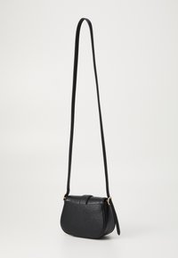 Malá černá kožená crossbody taška s dlouhým nastavitelným popruhem a zlatými kovovými doplňky, umístěná na jednoduchém světlém pozadí.