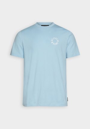 Camiseta de algodón de color azul claro con mangas cortas, cuello redondo y un logo blanco impreso en el área del pecho izquierdo. Textura suave, corte regular.