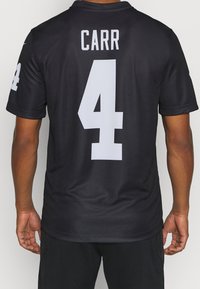 La camiseta deportiva negra presenta letras blancas con el nombre "CARR" y el número "4" en la parte posterior. Está hecha de un tejido suave y ligero.