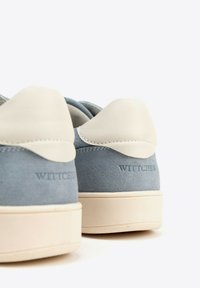 Sneakers in suede blu con un cappellino in pelle crema sul tallone, dettagli crema e logo "WITTCHEN" impresso sul lato. Suola in gomma bianca.