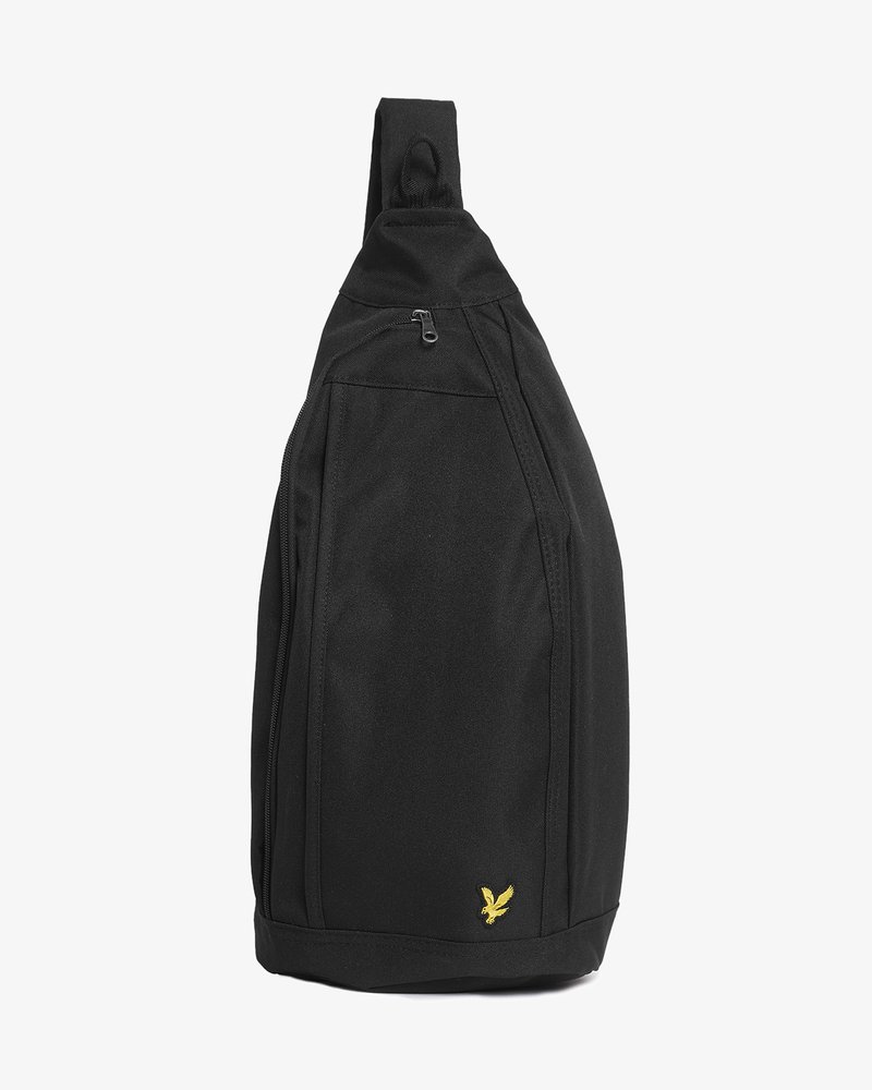 Črni nahrbtnik na eno ramo z enim trakom, z žepom z zadrgo spredaj in majhno rumeno orlovo logotipom pri dnu na belem ozadju.