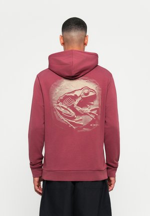 Maroon hooded sweatshirt featuring a large skeleton frog graphic in beige on the back, with ribbed cuffs and hem.