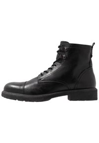 Svarta läderankelstövlar med rund tå, snörning framtill och två metalöglor. Har en texturerad yta och låg klossklack.