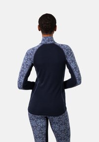 Langarm sporttop met een hoge kraag, gemaakt van een gestructureerde donkerblauwe stof. De mouwen hebben een geometrisch lichtblauw patroon.