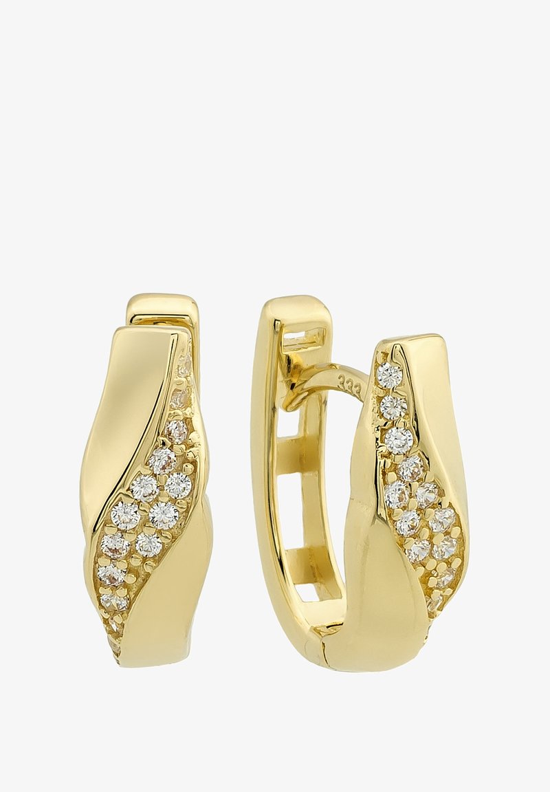 Boucles d'oreilles créoles dorées avec un design ondulé, ornées de diamants scintillants incrustés d'un côté, texture lisse et finition polie.