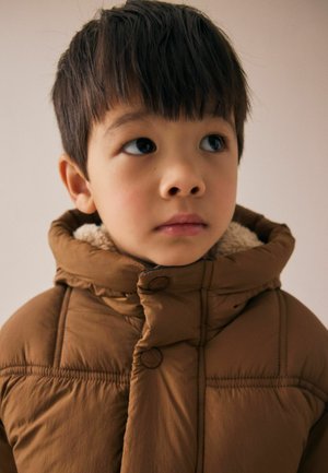 Veste rembourrée marron avec un col haut, dotée d'une doublure intérieure douce et de boutons. Le tissu semble lisse avec des sections matelassées.