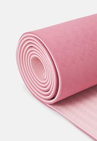 Roosa joogamat on tihedalt kokku rullitud, omades tekstuurset pinda, millel on lehe muster. Alusel on peen kootud disain ja kontrastne äär.