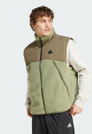 Mouwloos vest dat textuur groen fleecemateriaal combineert met een gladde olijfgroene bovenkant, met een hoge kraag, ritssluiting en subtiele branding.
