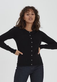 Cardigan nero lavorato a maglia con scollo a V, maniche lunghe e chiusura con bottoni metallici sul davanti, con tasche laterali e forma aderente.