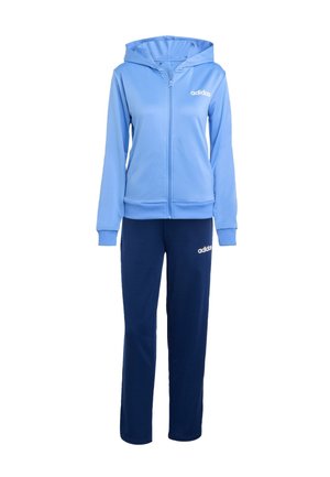 Blaue Zip-Hoodie mit Kapuze und Fronttaschen, kombiniert mit navy Jogginghosen, die einen elastischen Bund und weiße Logos haben.