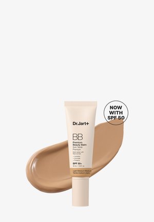 Tube de Dr. Jart+ BB Premium Beauty Balm avec SPF 50+ en teinte clair moyen, contre une trace du produit et une étiquette "Now with SPF 50".