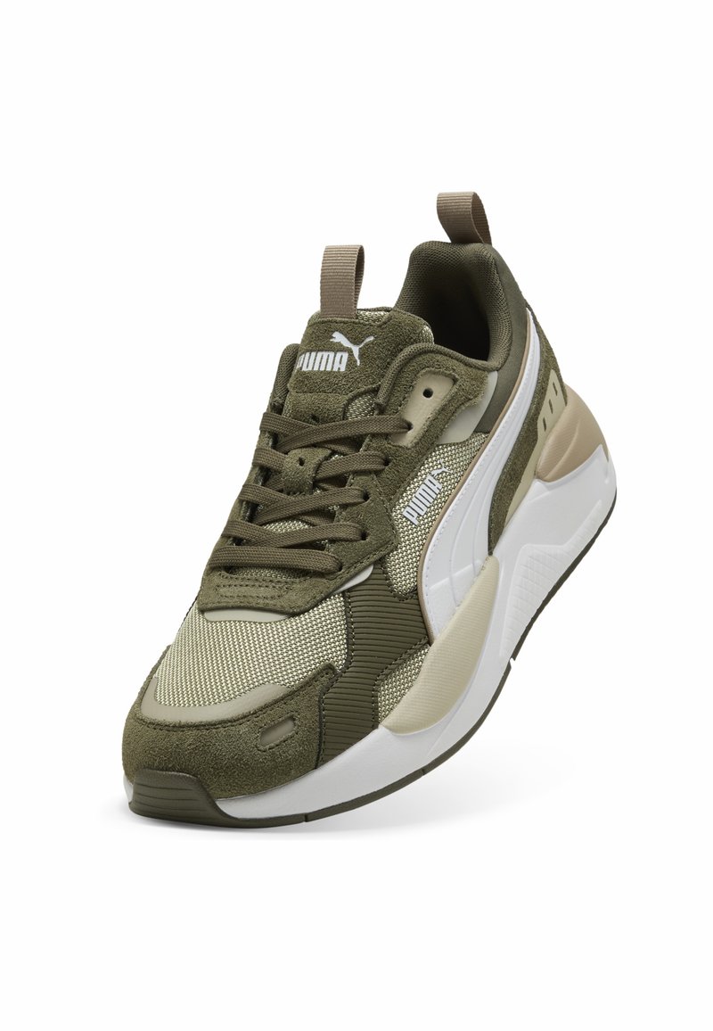 Baskets de sport vert olive avec une tige en mesh texturée, des accents en suède et une semelle en caoutchouc blanc. Présente un système de laçage et une languette à l'arrière.